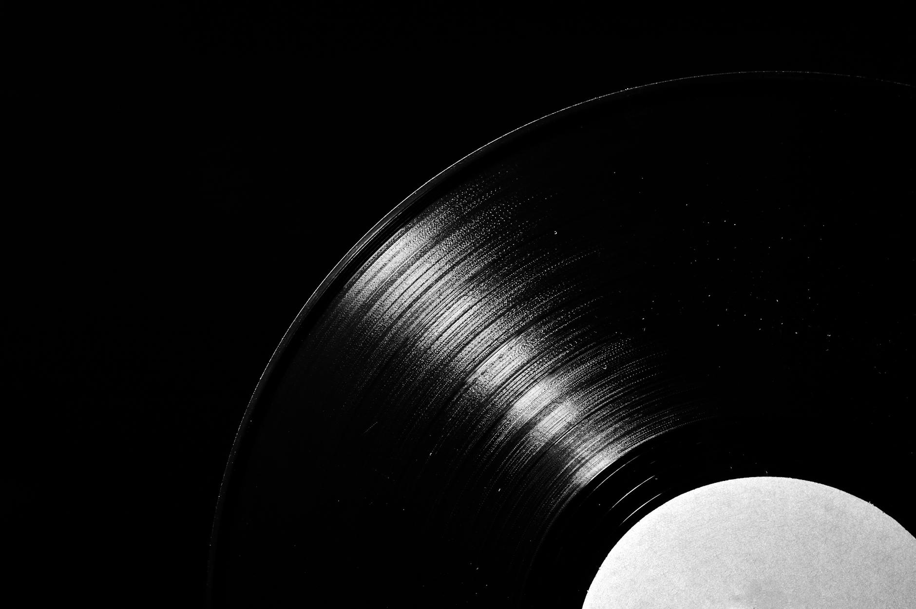 Detailed close-up shot of a vintage vinyl record against a dark background, highlighting grooves and texture.