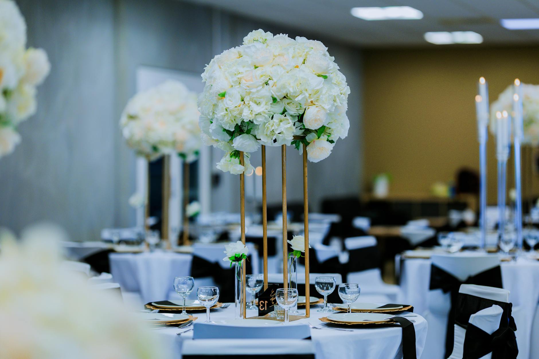 Stylish wedding reception with ornate floral centerpieces and elegant table settings.